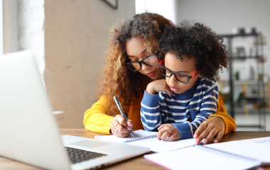 Woman and child writing on paper