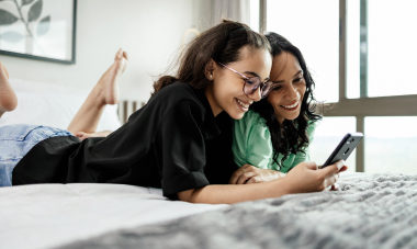 Woman and daughter looking at phone