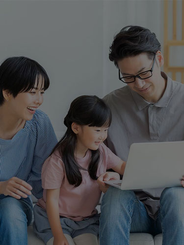 Happy family looking over a laptop
